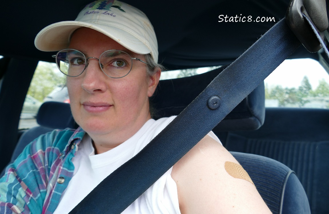 Me in the car, showing off my vax bandaid