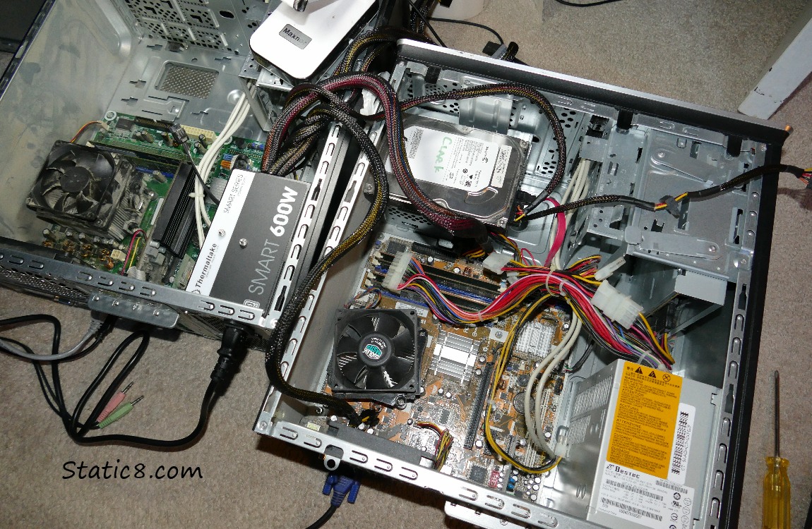 Two open computers with cables all over the place