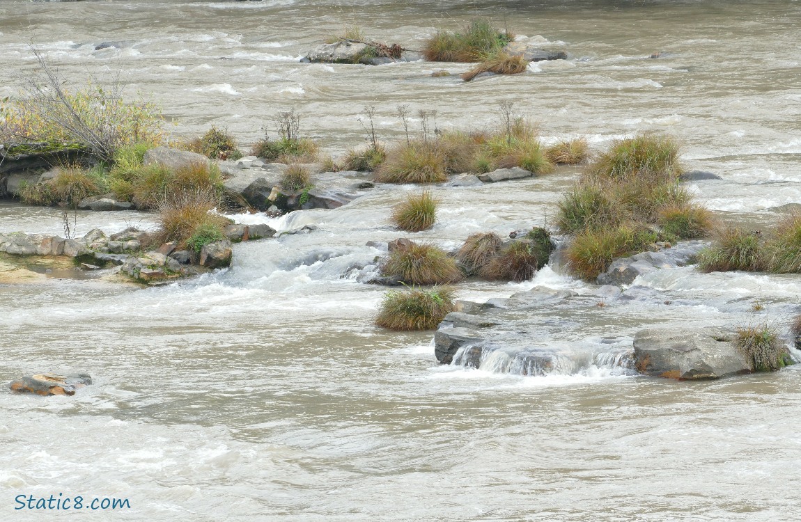 river going over grassy rocks