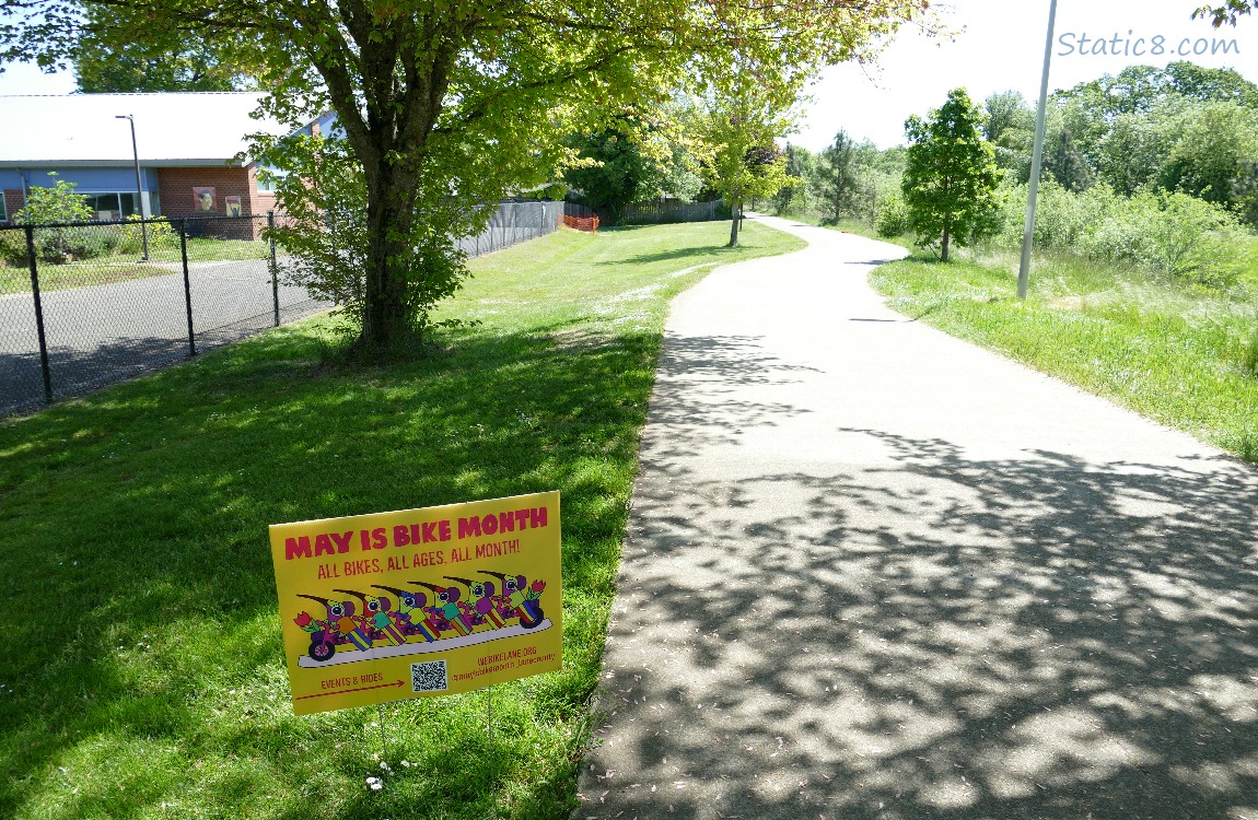 Path with a sign that says May is Bike Month
