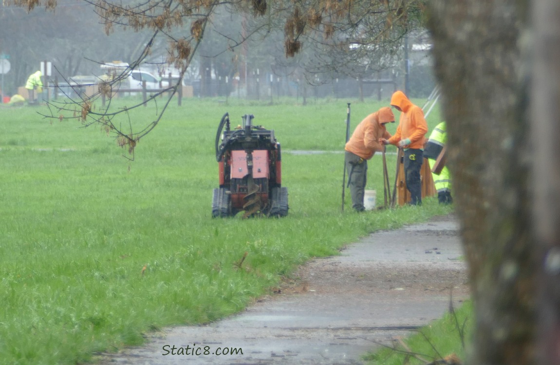 Men in rain gear working next to the path