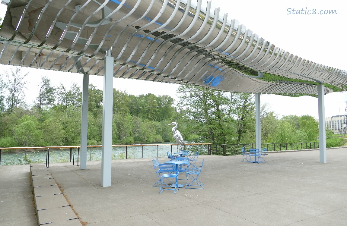 Art pavilion and heron statue in front of the river
