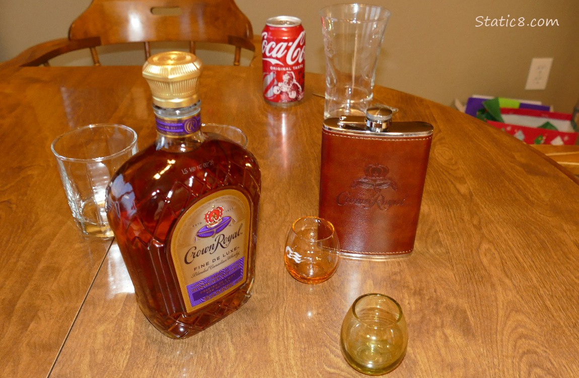Crown Royal bottle and flask with empty glasses