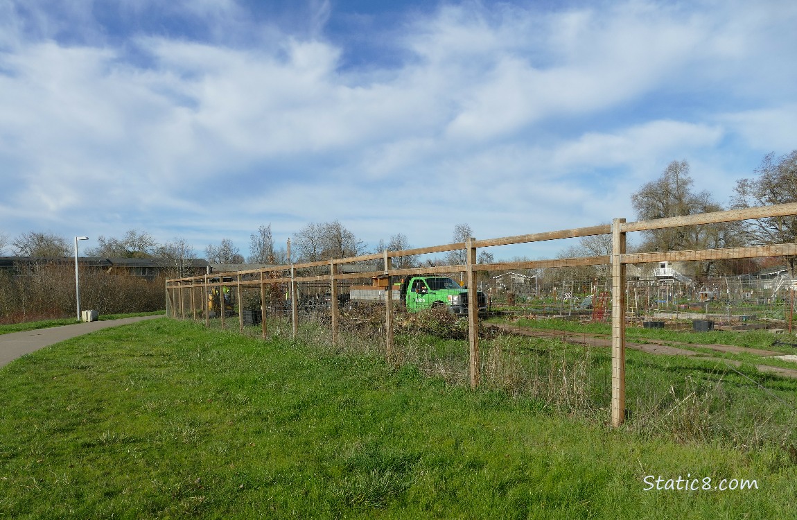 Work truck behind a wire and wood fence