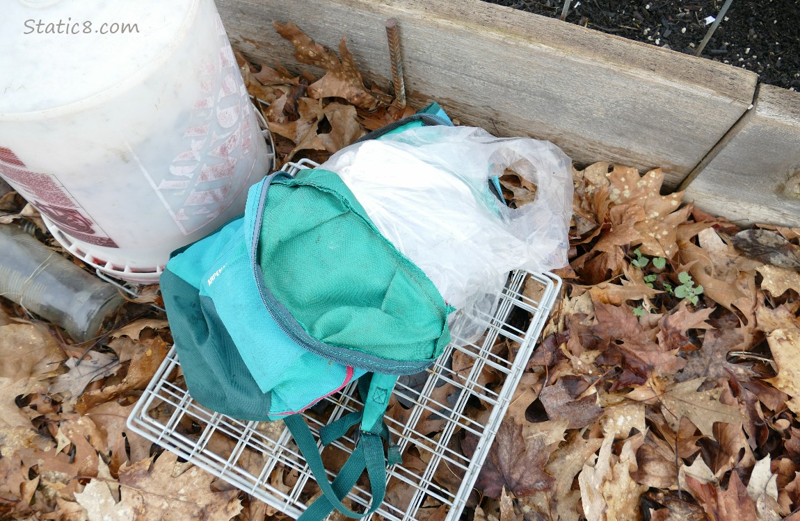 Green backpack filled with a white trash bag