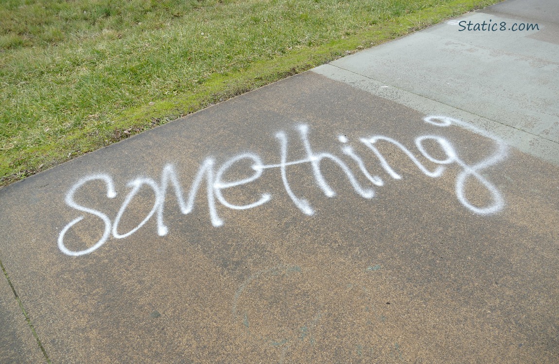 Graffiti on the bike path says Something