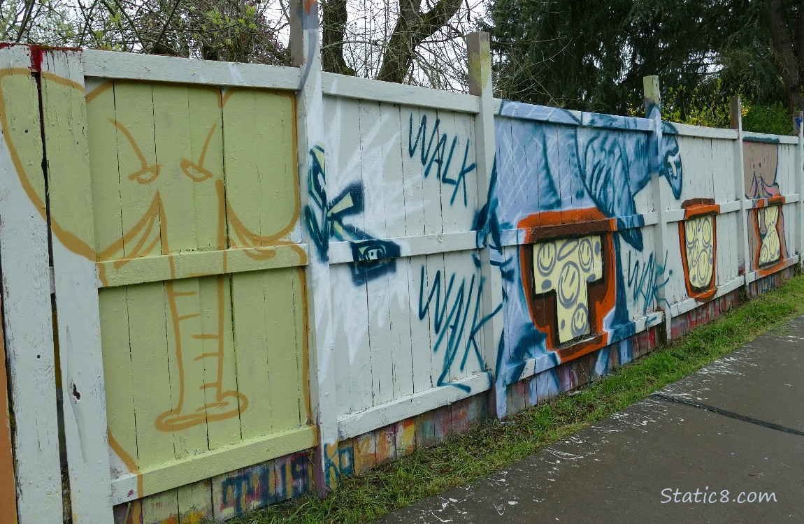 Elephants and other graffiti oon a wood fence