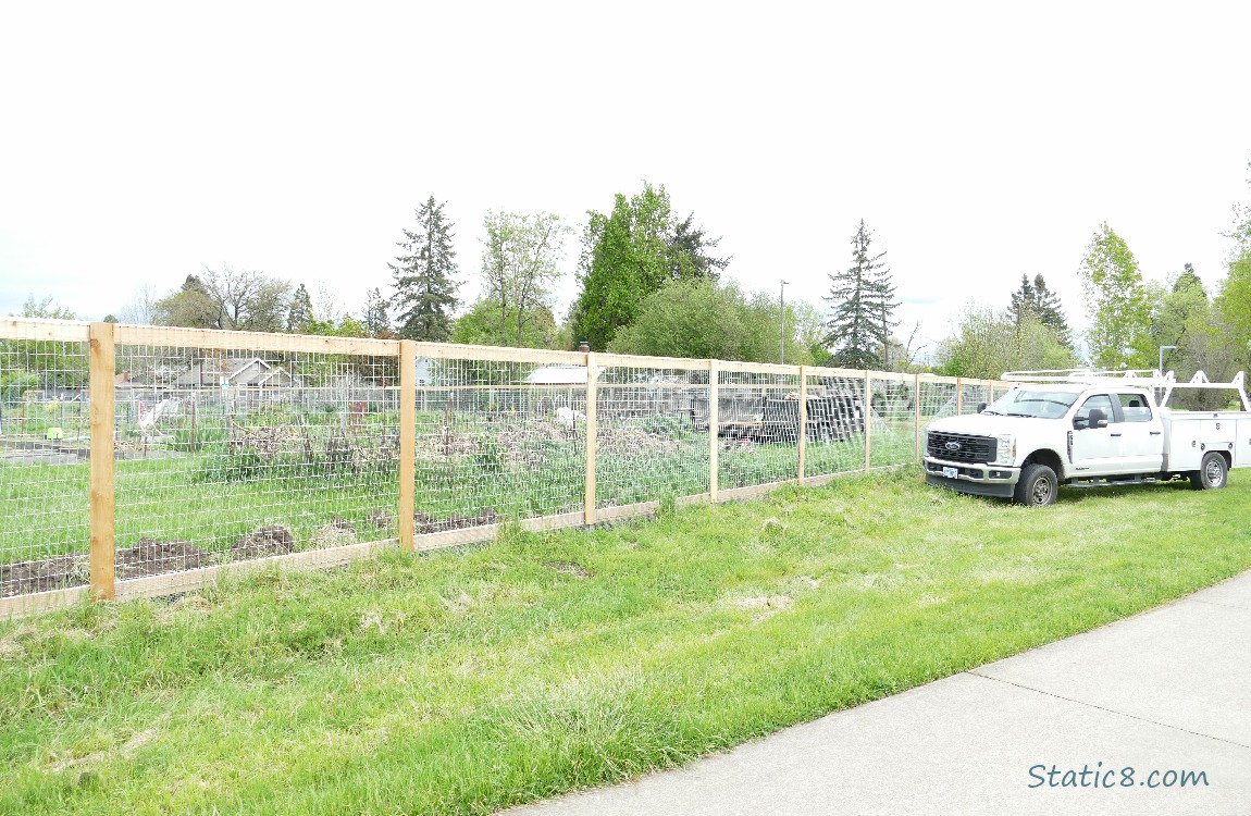 Fencing around a garden with a work truck parked next to it