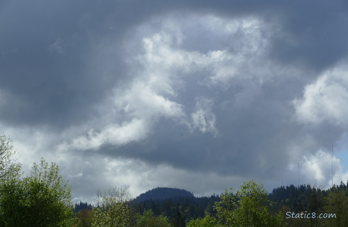Grey clouds over the hill in the distance