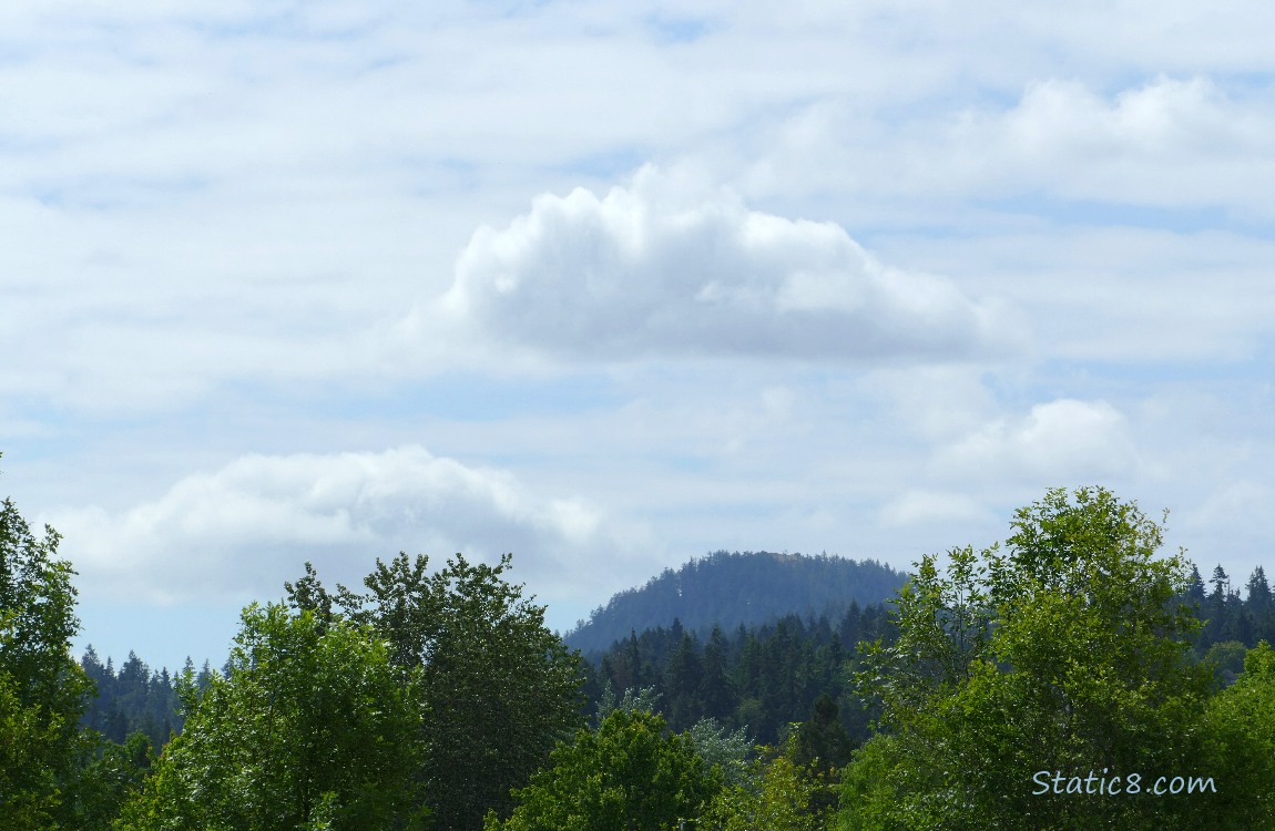 Small puffy clouds over the hill in the distance